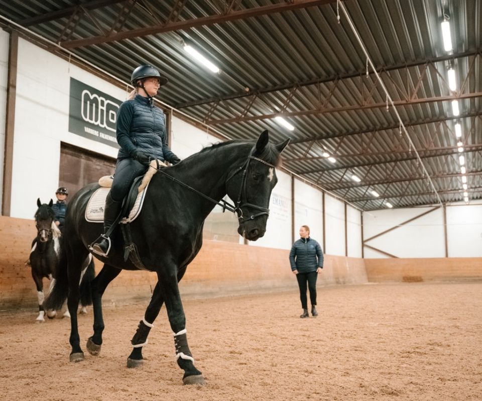 Elev rider på ridlektion i ridhuset
